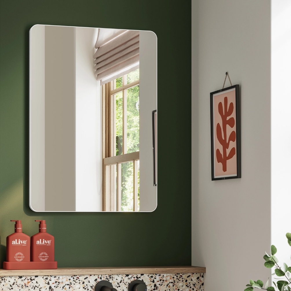 Lifestyle image of the hib. Trim Curve 400mm x 600mm Matt White Bathroom Mirror mounted on a green bathroom wall